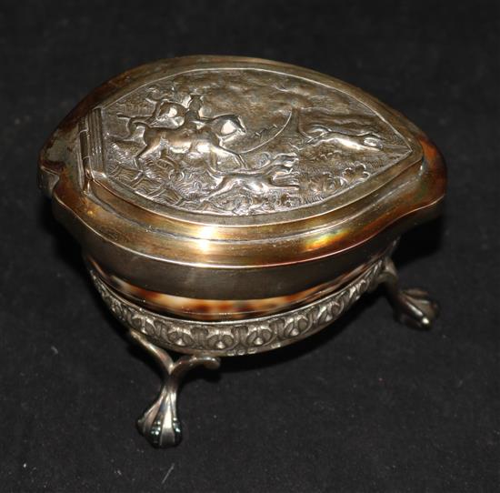 A 19th century cowrie shell table snuff box, with plated embossed hinged cover and stand